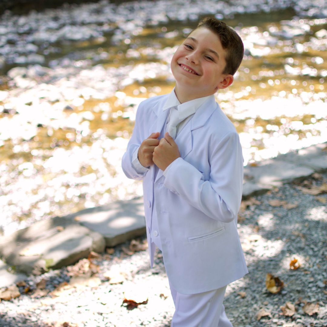 Boy in a white communion suit smiling