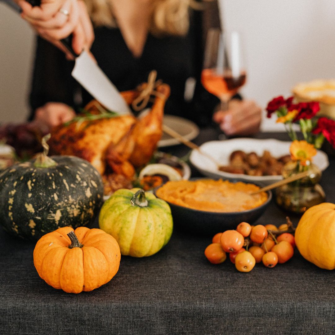 person carving turkey on thanksgiving table