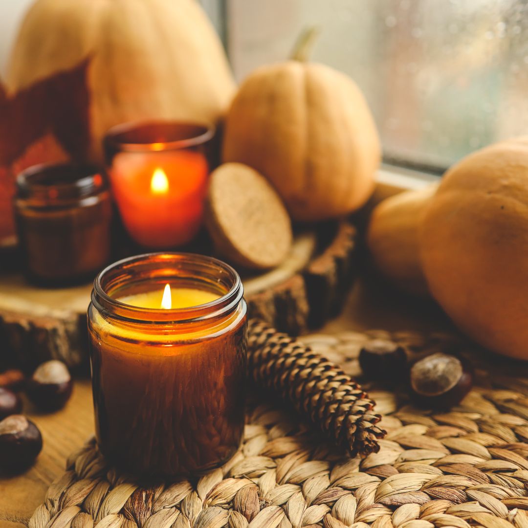 candle burning on autumn table setting