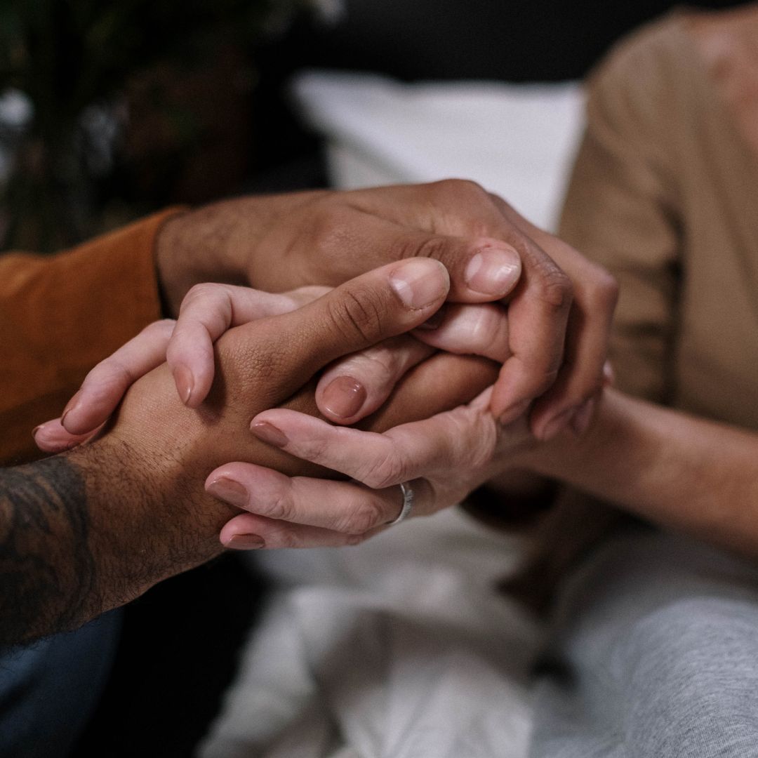 people gently holding hands